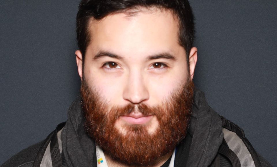 Image of Timothy. Brown eyed man with short black hair and a red beard. 